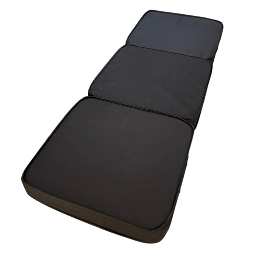 Colchón tipo maletín plegado con asas, ideal para transporte fácil.

